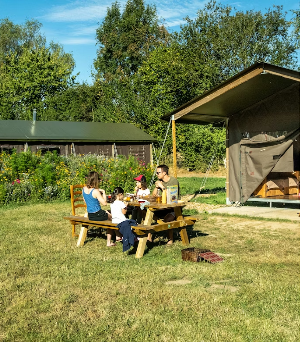 Déjeuner en famille sur la terrasse d'un écolodge à la ferme